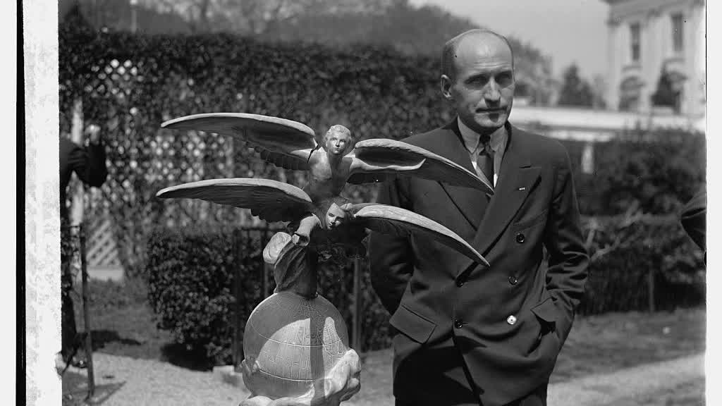 Carl Ben Eielson stands beside the Harmon Trophy in Washington in 1929.